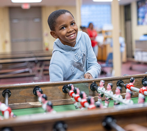 kid playing foosball